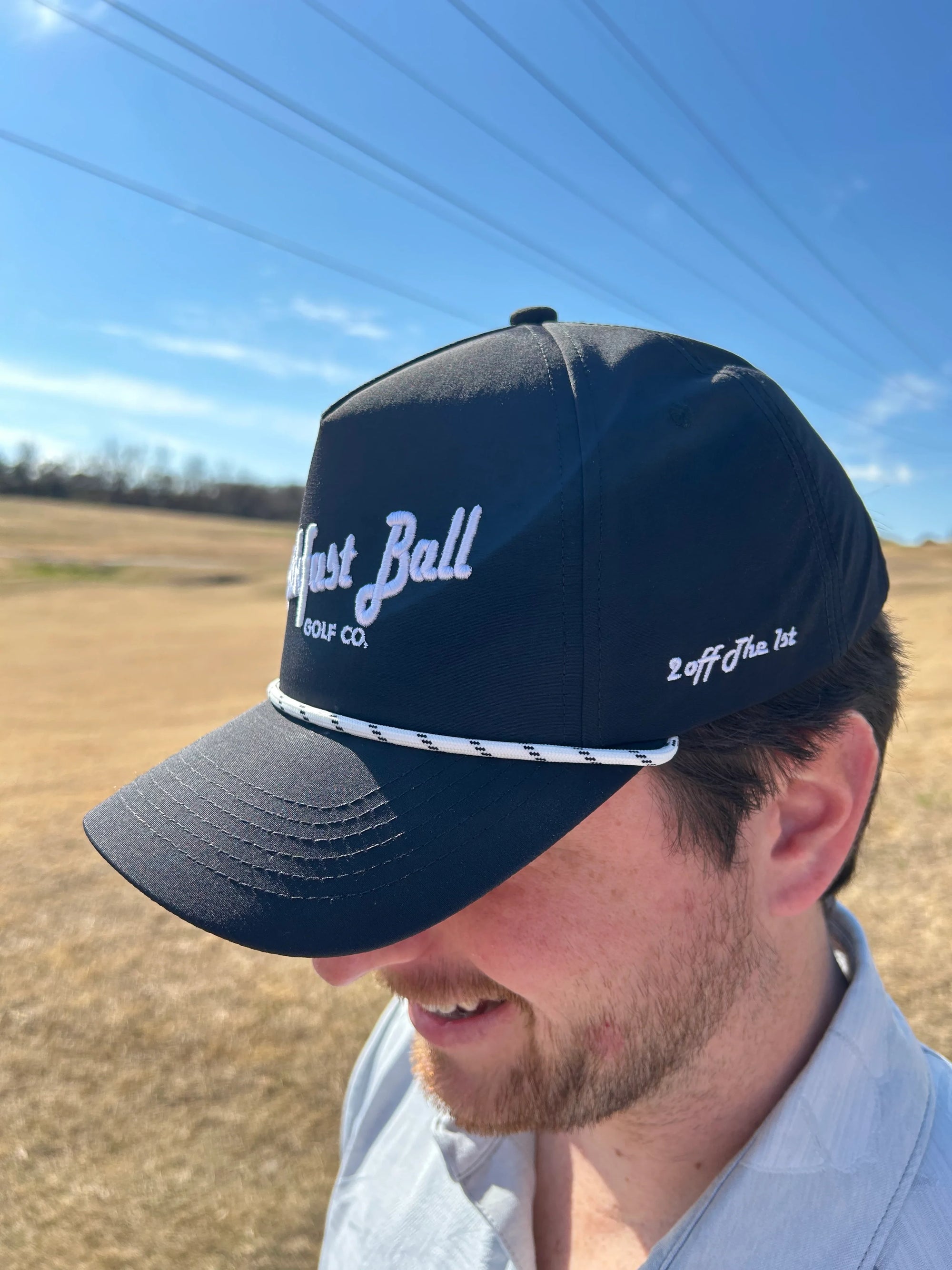 Man wearing a navy blue cap with branding in an outdoor setting