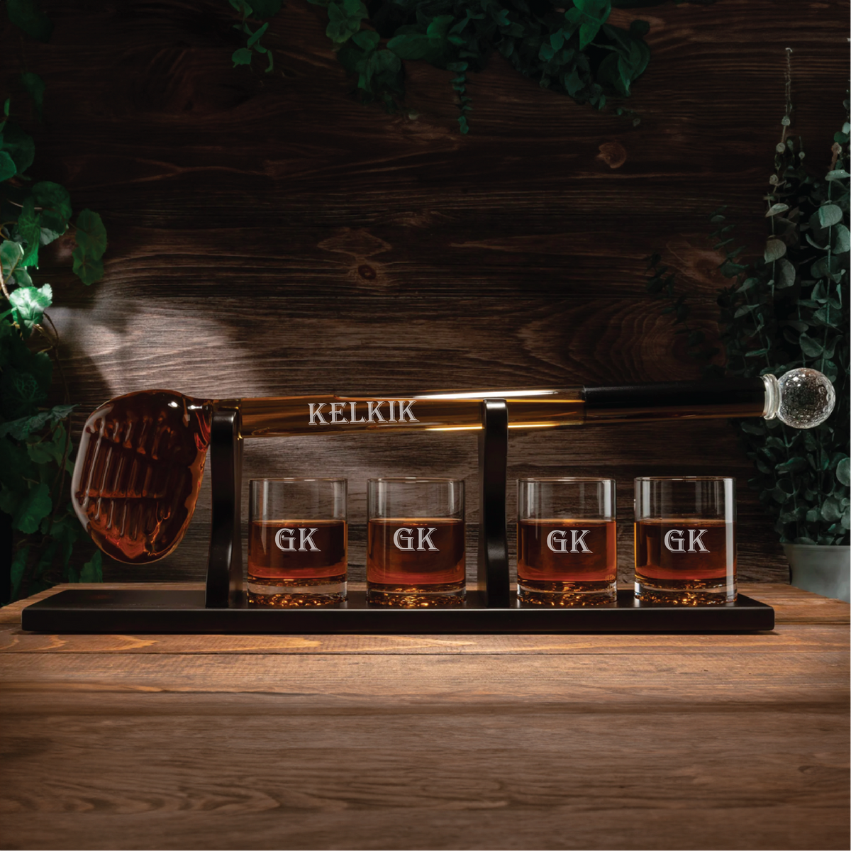 Personalized golf club whiskey decanter with ball glasses on a wooden tray.