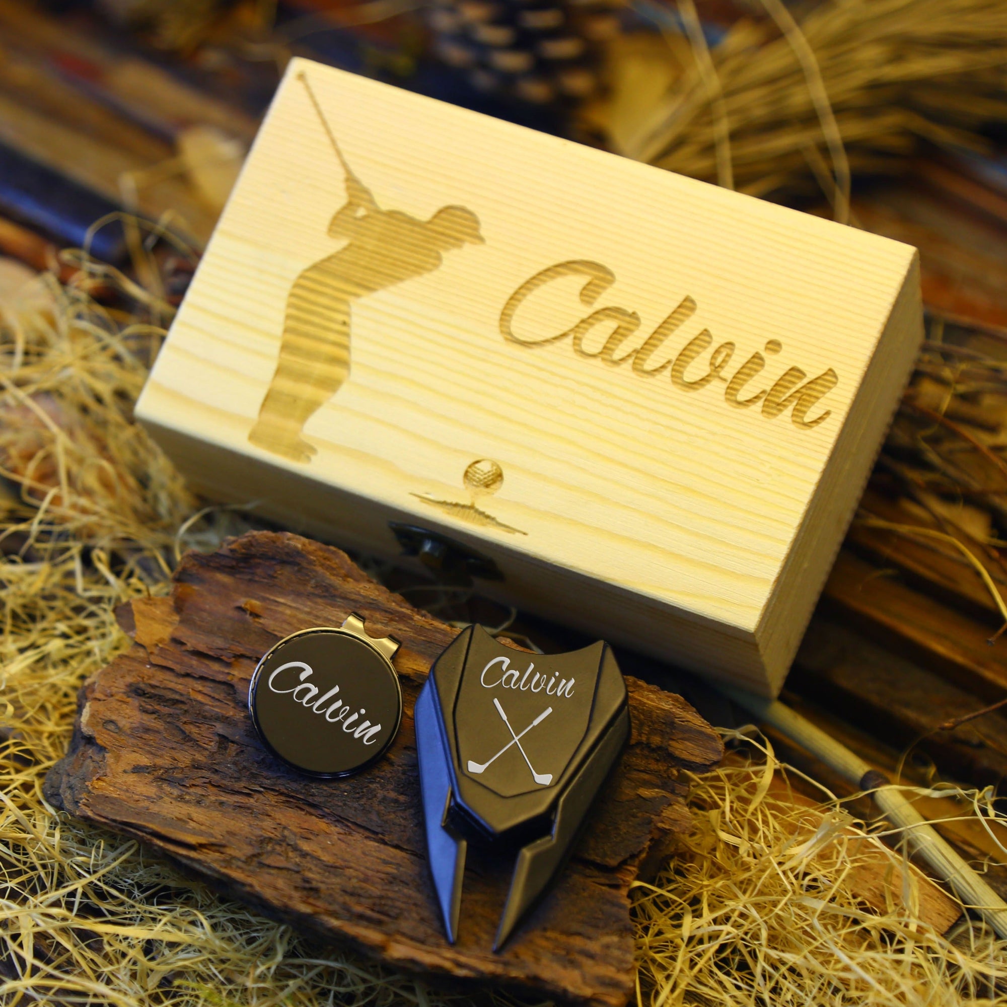 Golf accessory gift set with divot tool, ball marker, and personalized storage box.